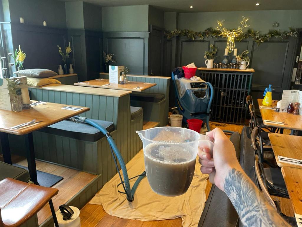 cover photo showing set up in restaurant holding jug of dirty water
