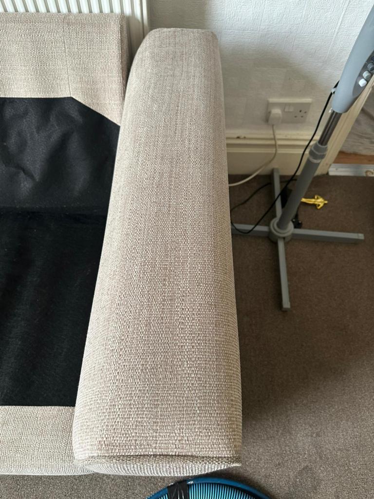 arm of a light coloured fabric sofa showing marks and dirt no longer visible after cleaning